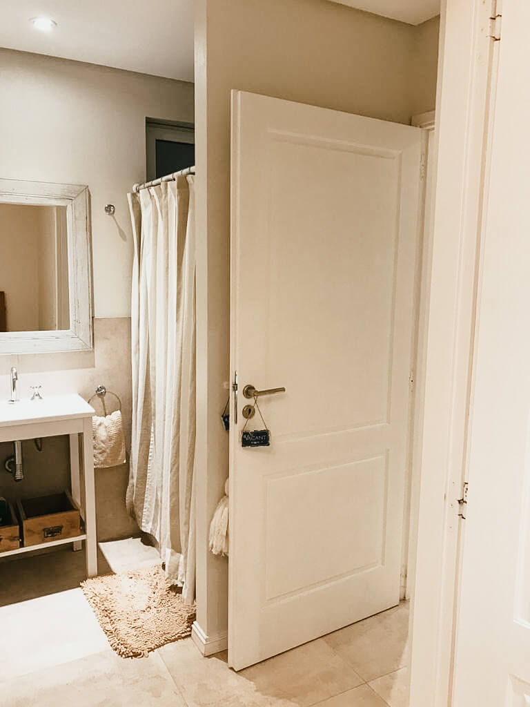 Entrada a un baño con vistas de parte de la ducha y el vanitory