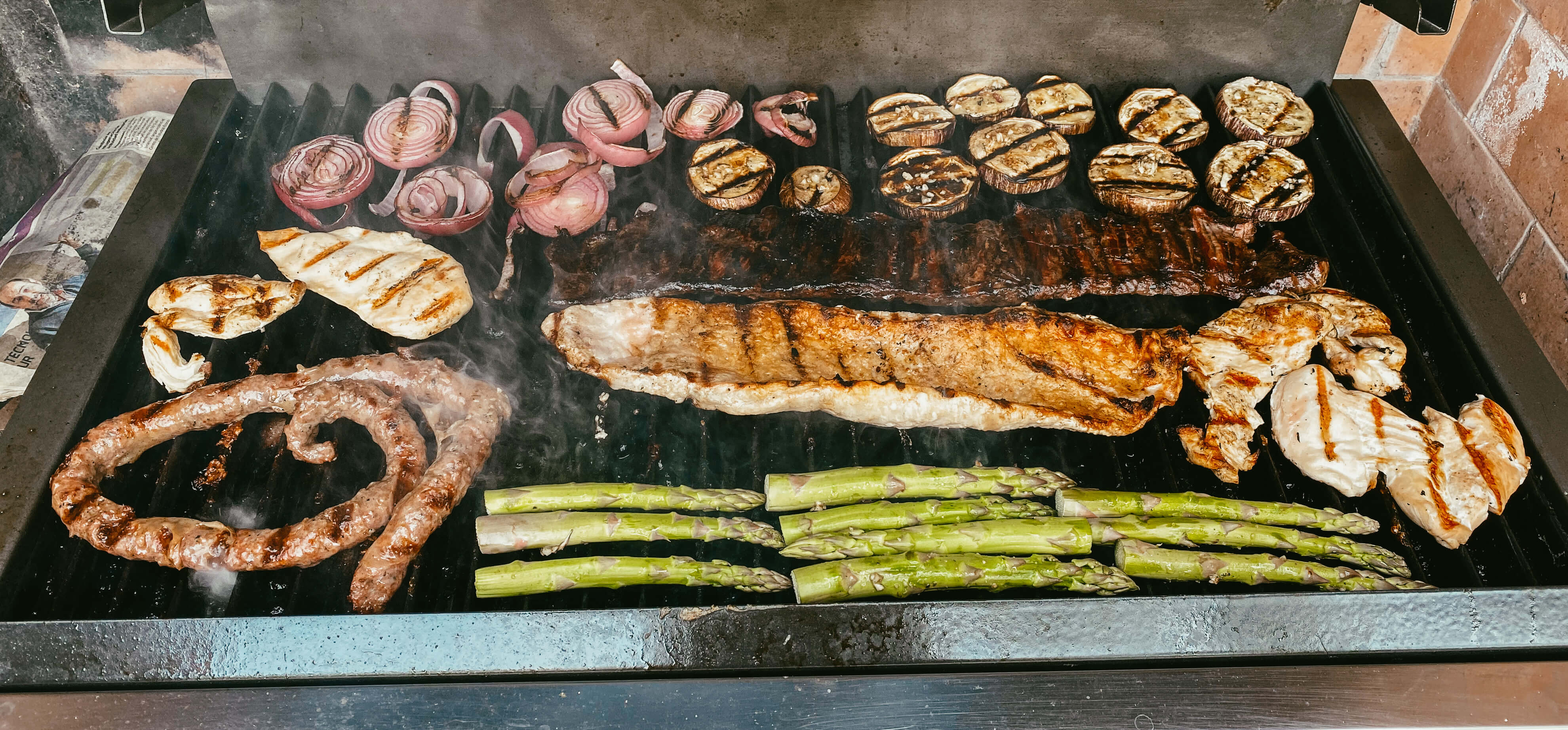 Parrilla con espárragos, cebolla morada, berenjenas, pollo, salchicha parrillera y entraña